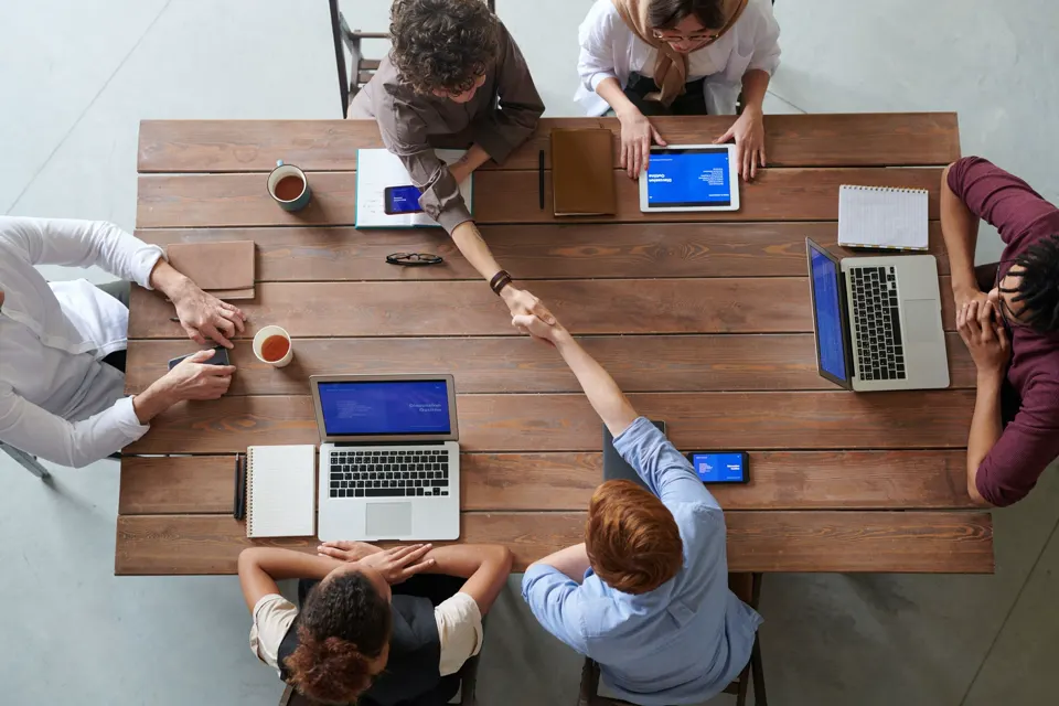 An overhead view of a working meeting around a table.