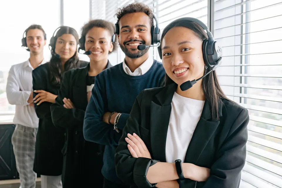 Adults wearing headsets at a service desk.