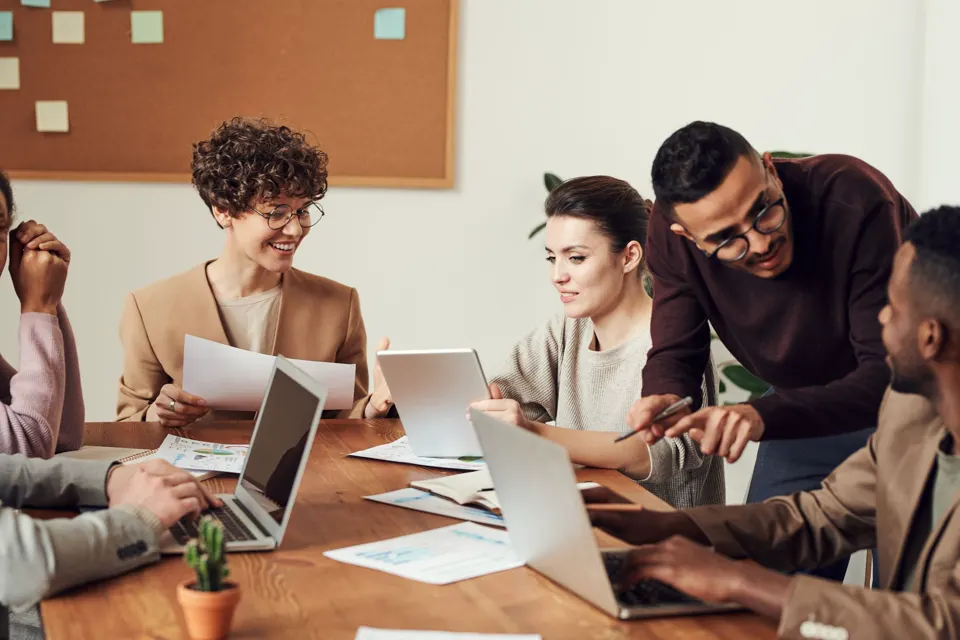 Colleagues around a meeting table in a bright office.